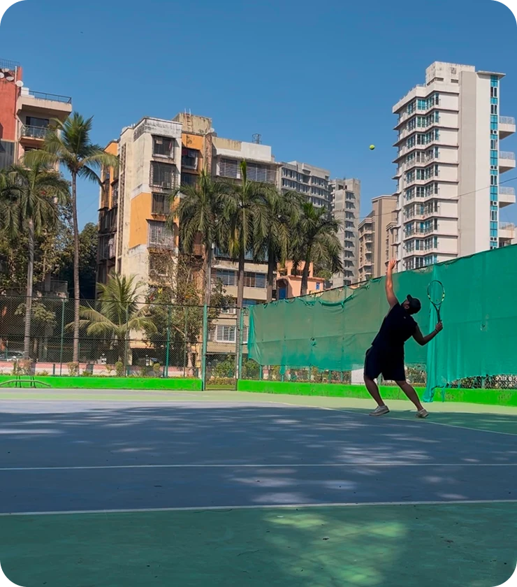 Sumeet playing tennis on an outdoor court